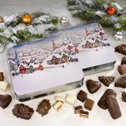 Winter village gift tin surrounded by gingerbread confectionery Winter village gift tin surrounded by gingerbread confectionery